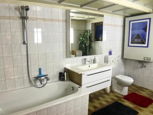 a bathroom with a tub and a sink and a toilet at Charming Apartment with Mountain View in Altmünster