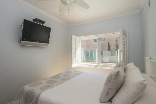洛杉磯的住宿－海灘威尼斯酒店，白色卧室配有床和平面电视