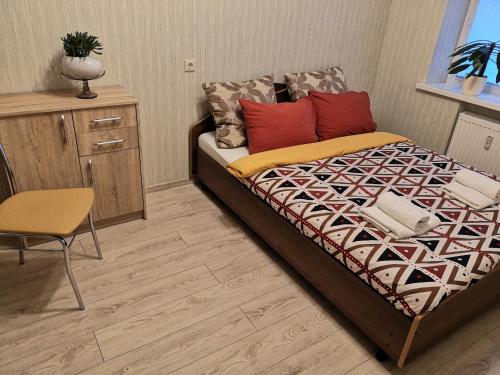 a bedroom with a bed and a desk and a chair at Raudondvario II in Kaunas