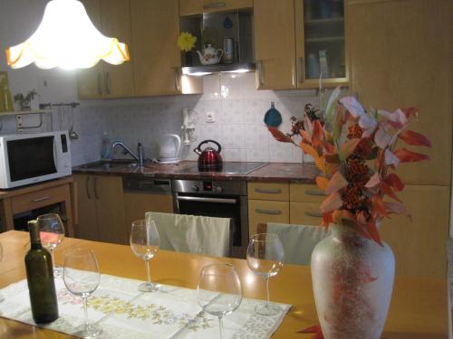 a kitchen with a table with wine glasses and a vase with flowers at Apartment Ferrari in Portorož