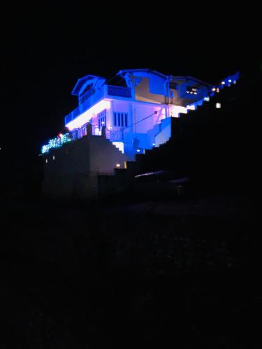 a house lit up in blue at night at Aqua De Vida in Bhowāli