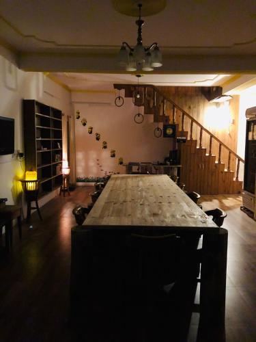 a large wooden table in a room with a staircase at Aqua De Vida in Bhowāli