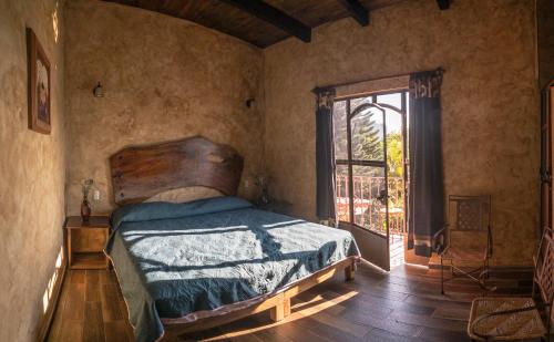 a bedroom with a bed and a window at Flor de Cera in Tepoztl&aacute;n