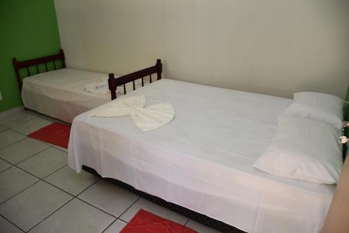 two beds with white sheets in a room at Estância Cyclo das Águas in Nobres