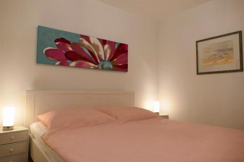 een slaapkamer met een bed met 2 lampen en een schilderij aan de muur bij BaskoParadis I Apt I Spacieux I Douillet I Coloré I Lit 160 I Terrasse I Patio in Cambo-les-Bains