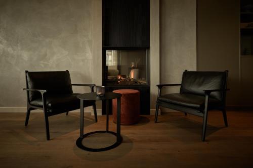 two chairs and a table in a room at Hotel de Blanke Top in Cadzand-Bad
