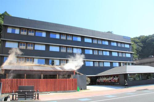 a black building with smoke coming out of it at Iseya, Seaview Private Oceanside Bath in Unzen