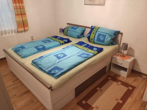 un letto con cuscini blu sopra di Ferienwohnung Cziesla a Bad Sachsa