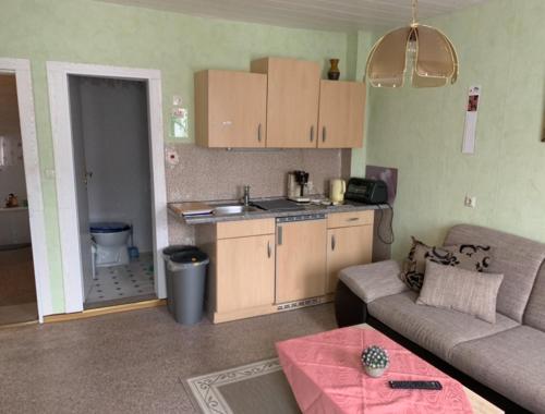 ein Wohnzimmer mit einem Sofa und einer Küche in der Unterkunft Ferienwohnung Cziesla in Bad Sachsa