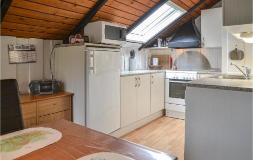 a kitchen with white appliances and a wooden ceiling at Holiday Home Søknudevej Iv in Ansager