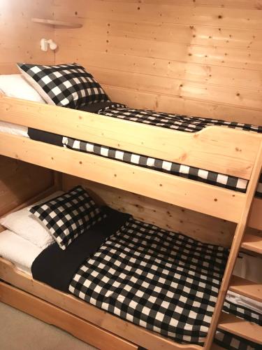 - un lit superposé avec des draps et des oreillers en noir et blanc dans l'établissement Résidence L’Etendard, à Les Deux Alpes
