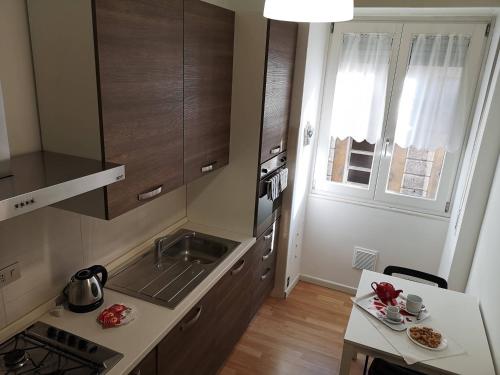 a kitchen with brown cabinets and a table and a window at Italianflat - Arena di Verona, Elegant 2 Bedrooms in Verona