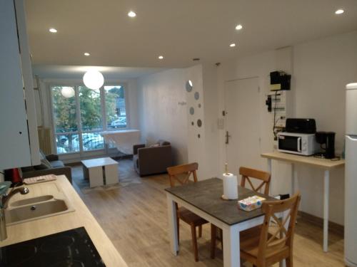 cocina y sala de estar con mesa y sillas en Nouveau! Appartement 80m2 tout neuf avec 3 belles chambres, en Tours