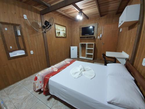 a bedroom with a bed with a bow on it at Residencial Rei Thomas in Capão da Canoa