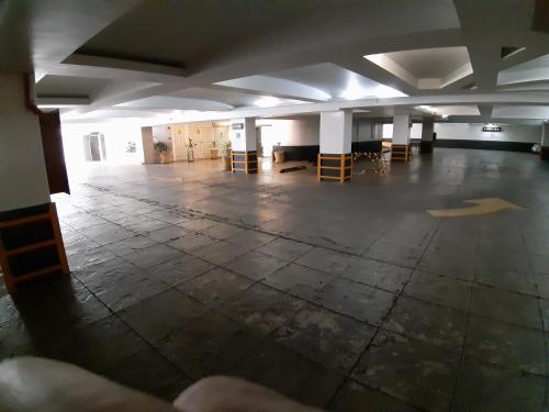 an empty room with tables and chairs in a building at AUTO HOTEL LEGARIA in Mexico City