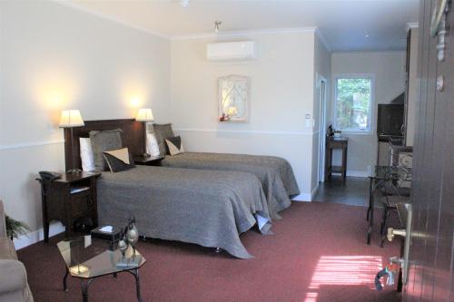 Habitación de hotel con cama y TV en Lodge Bordeaux en Whangarei