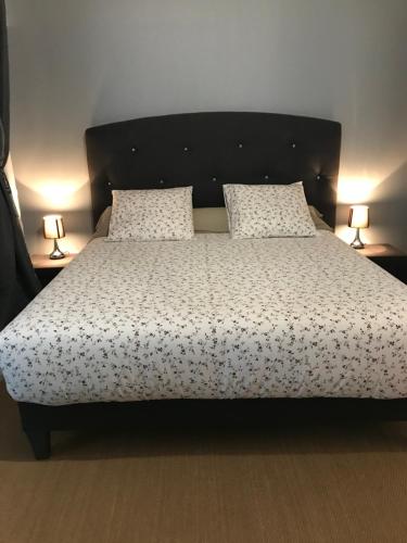 a bedroom with a large bed with two lamps at Le Cheval Bleu in La Baule