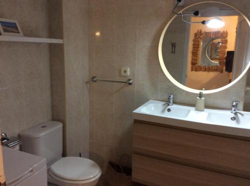 a bathroom with a toilet and a sink and a mirror at Bilocale vista mare Es Pujols in Es Pujols