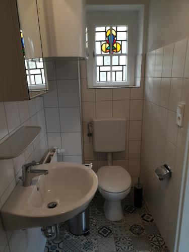 łazienka z toaletą, umywalką i oknem w obiekcie Apartment 23 w mieście Coburg