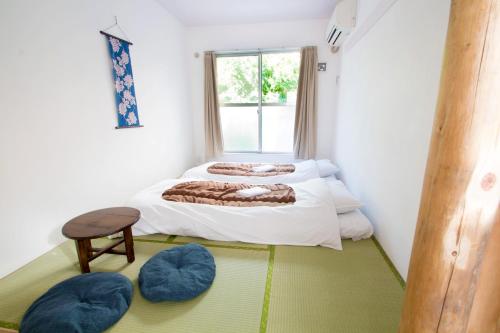a bedroom with two beds and a window at Sakura Hotel Nippori in Tokyo