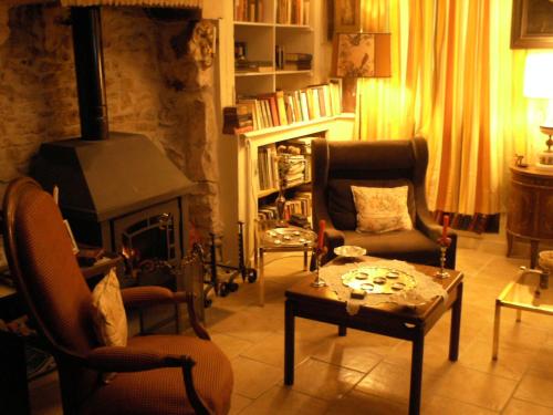een woonkamer met een open haard en een bank en stoelen bij Maison de la Loire in La Charité-sur-Loire