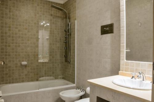 uma casa de banho com um lavatório, uma banheira e um WC. em Aguas Claras Hosteria em Santa Rosa de Calamuchita