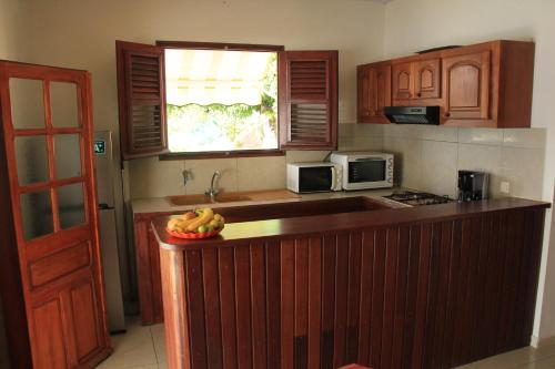 a kitchen with a bowl of bananas on a counter at Résidence Séjourné in Les Anses-dʼArlets