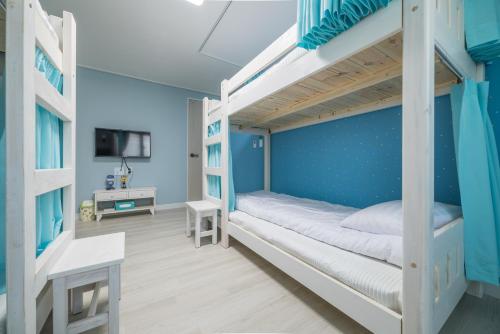 um quarto com beliches e uma parede azul em DreamTrip Guesthouse em Incheon