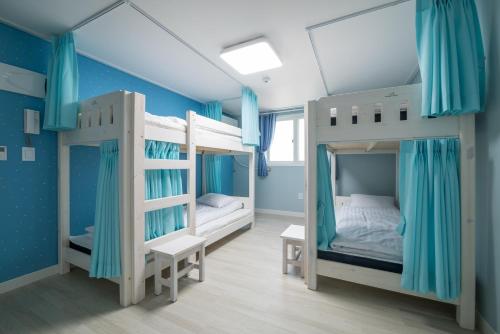 two bunk beds in a room with blue walls at DreamTrip Guesthouse in Incheon