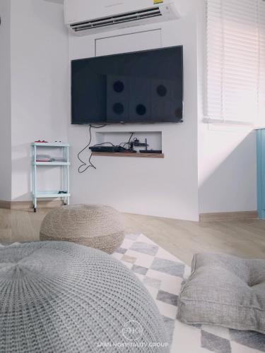 a living room with a flat screen tv on a wall at Stay in Style at Nimman R918 in Chiang Mai