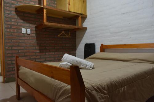 Dos camas en una habitación con una pared de ladrillo. en Cabañas Rayuela y otros cuentos, en Santa Rosa de Calamuchita