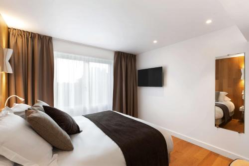 a bedroom with a large bed and a large window at Best Western L'Aquarium Arras Nord in Fresnes-lès-Montauban