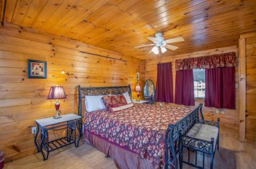 a bedroom with a bed and a ceiling fan at Ladybug Resort Romantic Cabin With Mountain Views, Game Room, Close to Dollywood in Sevierville