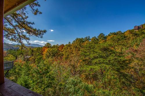 a view from the deck of a house with trees at Ladybug Resort Romantic Cabin With Mountain Views, Game Room, Close to Dollywood in Sevierville