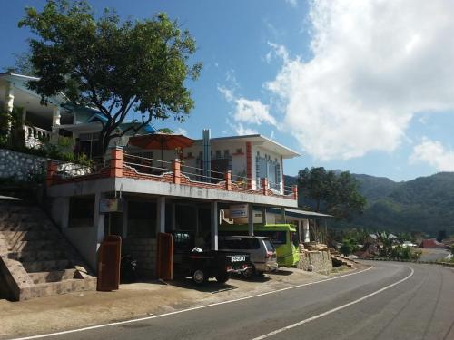 uma casa ao lado de uma estrada em Bintang Bungalow Tour & Travel em Kelimutu