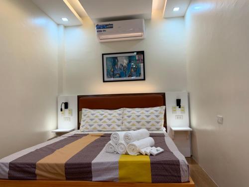 a bedroom with a bed with towels on it at Rustic Crown Hotel in Alaminos