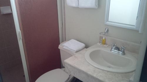 a bathroom with a white toilet and a sink at CHN Hotel Monterrey Santa Fe in Monterrey