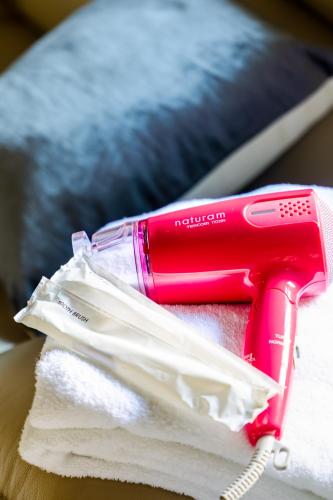 a pink hair dryer sitting on top of towels at Family house (private house) in Osaka