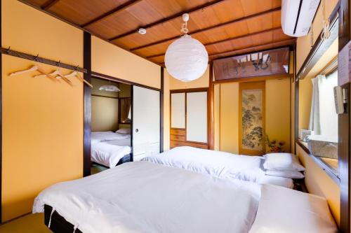 two beds in a room with yellow walls at Family house (private house) in Osaka