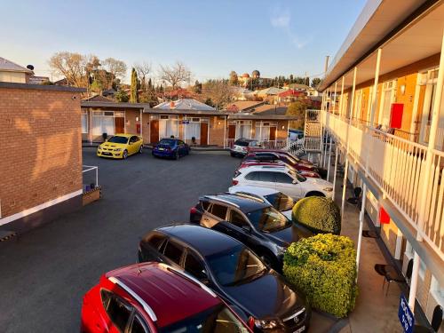 a row of cars parked in a parking lot at Queanbeyan Motel in Queanbeyan