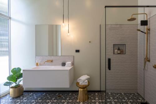 a bathroom with a tub and a shower with a sink at The Burlington Luxury Octagon Apartment in Dunedin