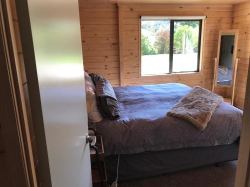 a bedroom with a bed and a window at Aroha Anchor Apartment in Motueka