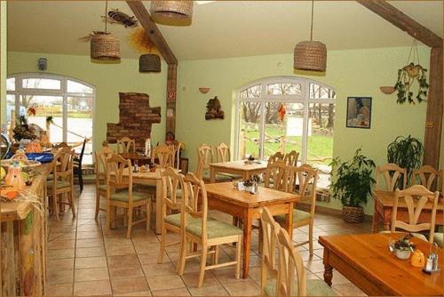 een eetkamer met houten tafels en stoelen bij Landhotel zum Honigdieb in Ribnitz-Damgarten