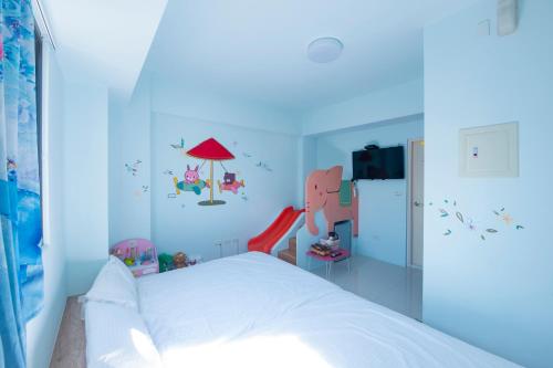 a bedroom with a bed in a blue room at Kids Heart Home in Fengyuan