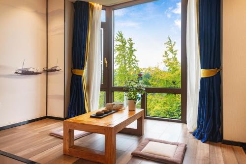 a living room with a table and a large window at Li River Resort Villa Hotel in Guilin