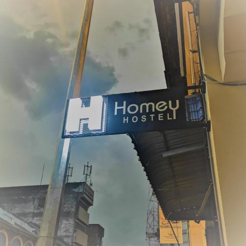 a sign for a honey hostel on the side of a building at Homey Hostel in Ipoh
