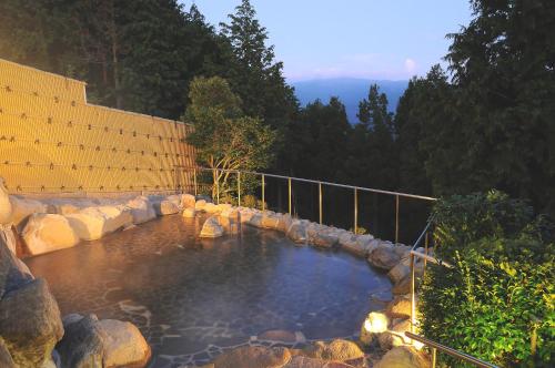 una gran piscina de agua con rocas en un patio en Yugashima Golf Club & Hotel Resort, en Izu