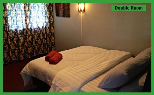 a bed with two pillows on it in a bedroom at Sukau Greenview Bed & Breakfast in Sukau