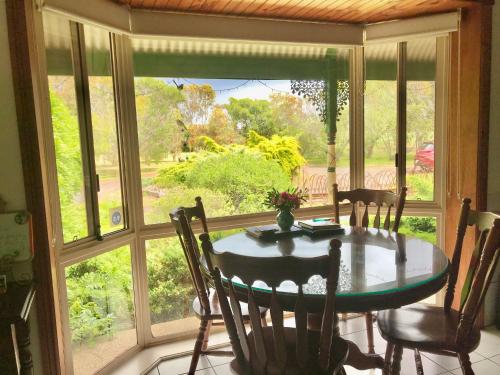 a dining room with a table and a large window at Fairy Wren Cottage Country to Coast Retreat in Wallington
