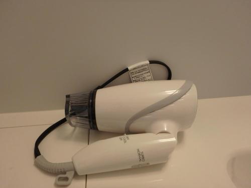 a white hair dryer sitting on a wall at 京の宿 西大路 familie in Kyoto
